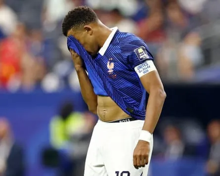 A dejected Kylian Mbappé puts his head in his shirt