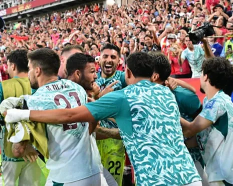 Gonçalo Ramos is swamped by teammates after scoring the winning goal in added time for Portugal.