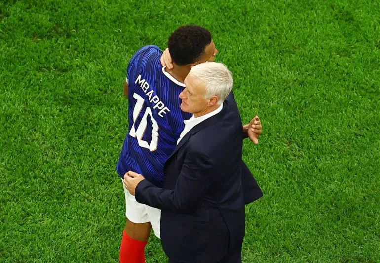 France's Kylian Mbappe embraces coach Didier Deschamps after the match