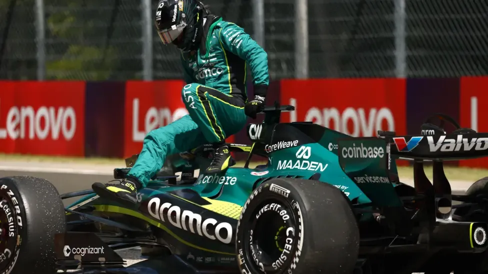 Lance Stroll climbs out of his Aston Martin after it suffered a suspension failure during Hungarian Grand Prix first practice