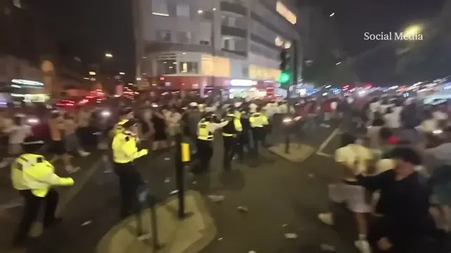 Police appear to be chased down Edgware Road by football fans after Morocco's World Cup loss to France