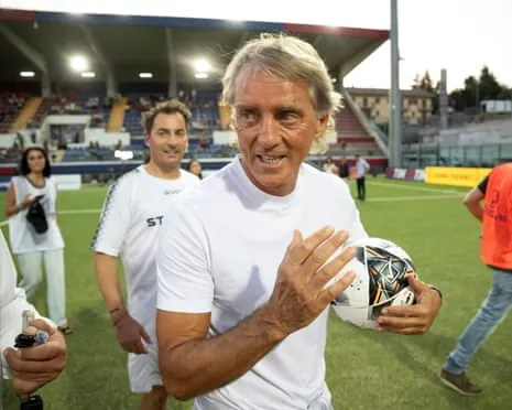 Roberto Mancini holds a football after a charity match in L’Aquila this month