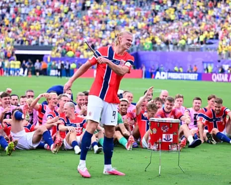 Erling Haaland beats the drum during Norway post-game celebrations on the pitch after his goals defeated Brazil in the World Cup last-16 tie.