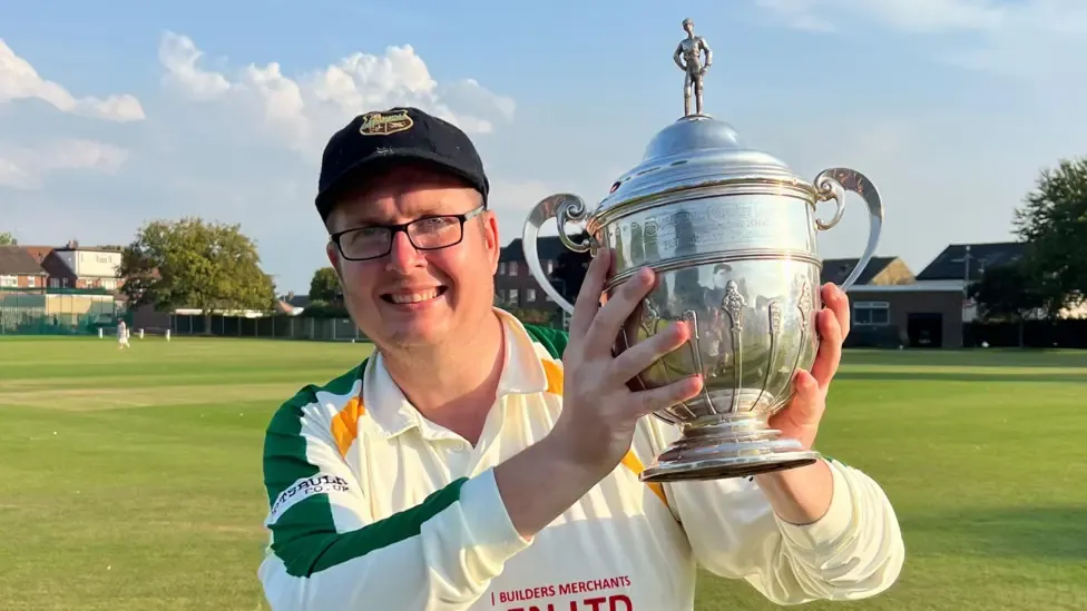 Brian Devine holding a trophy from the Bradford Cricket League in 2023