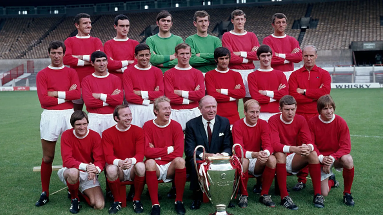 MANCHESTER, ENGLAND - JULY 25: European Cup winners Manchester United line up for a team photograph with the trophy at Old Trafford on July 25, 1968 in Manchester, England. Back row (left-right): Bill Foulkes, John Aston, Jimmy Rimmer, Alex Stepney, Alan Gowling and David Herd. Middle row: David Sadler, Tony Dunne, Shay Brennan, Pat Crerand, George Best, Francis Burns and Jack Crompton (trainer). Front row: Jimmy Ryan, Nobby Stiles, Denis Law, Sir Matt Busby (manager), Bobby Charlton, Brian Kidd and John Fitzpatrick. (Photo by W & H Talbot Archive/Popperfoto via Getty Images)